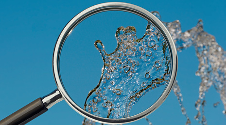 Lupe analysiert Trinkwasser