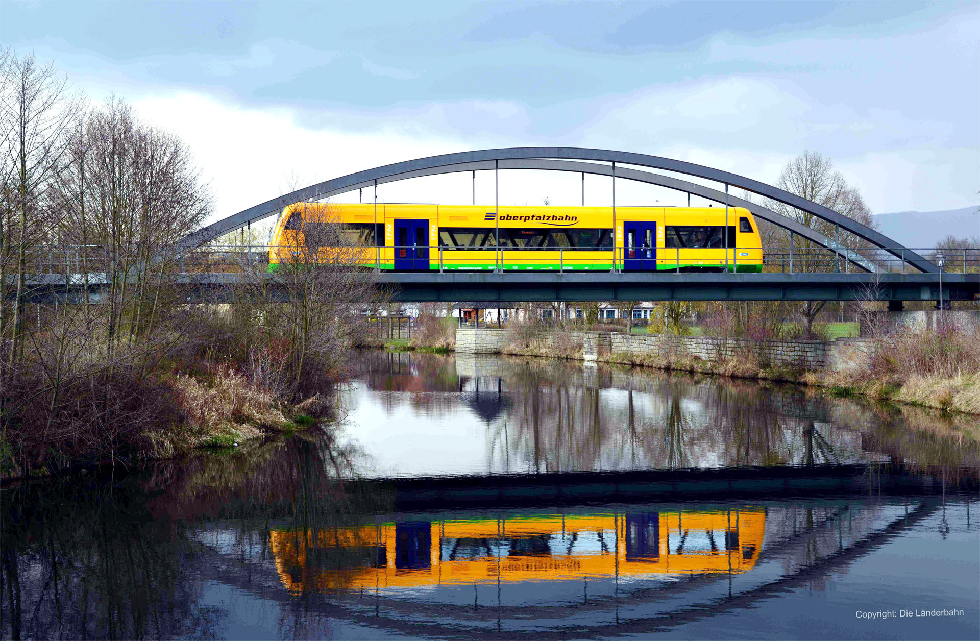 Oberpfalzbahn fährt über Eisenbahnbrücke über den Fluss Regen