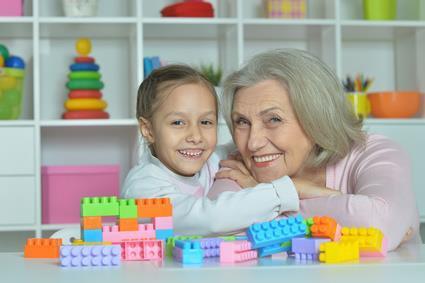 Großmutter und Enkelin spielen mit Legosteinen