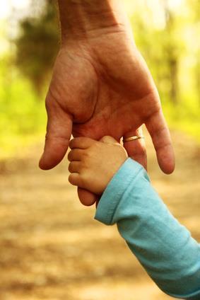 Eltern halten die Hand eines kleinen Kindes (Adobe Stock 113316807) Kleines Kind hält sich an der Hand seines Vaters fest