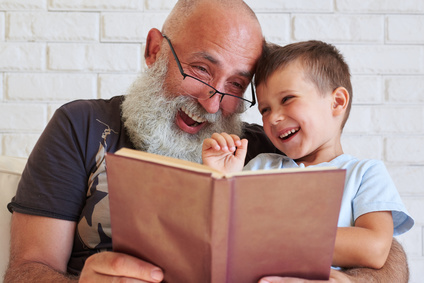 Alter Mann und Enkel haben Spaß daran, gemeinsam ein Buch zu lesen