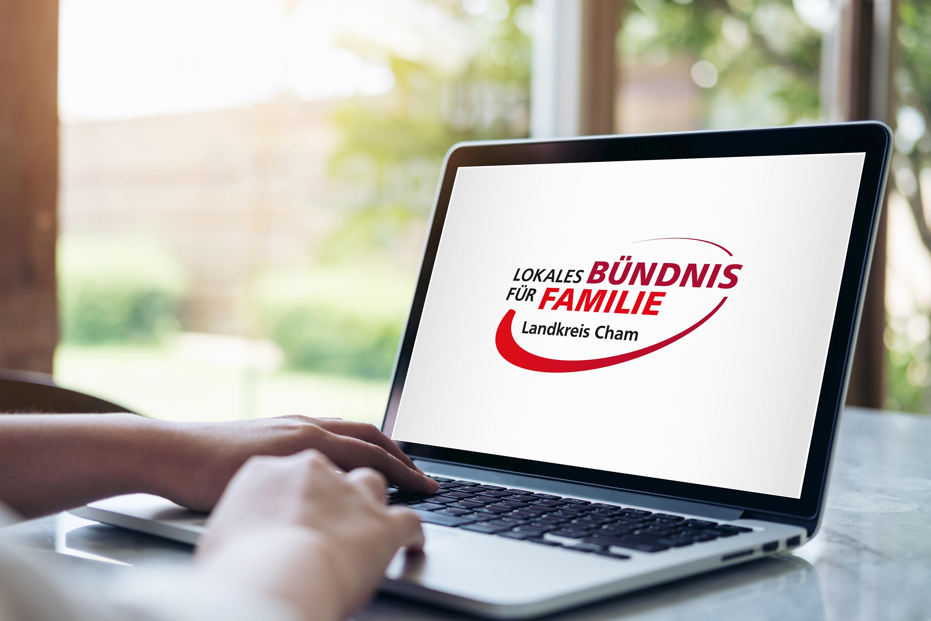 Hand mit Laptop und Bildschirm mit Logo Bündnis für Familie