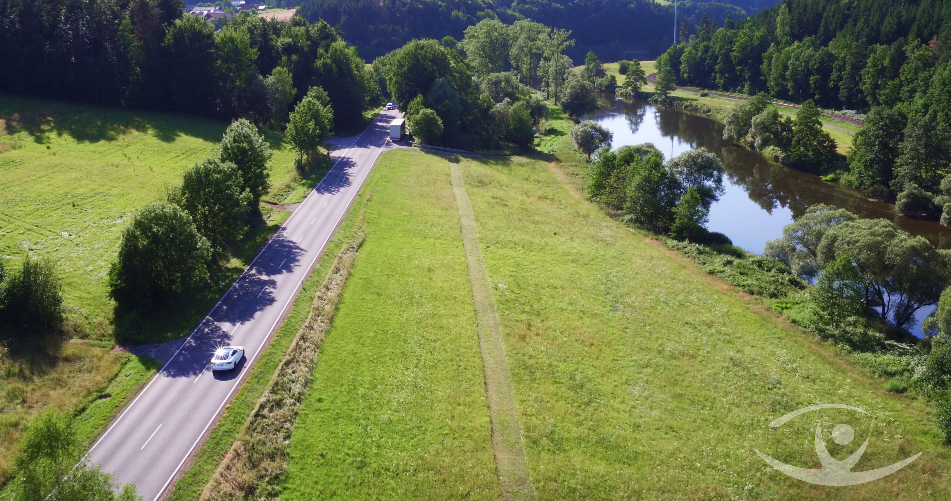 Luftbilld: befahrene Straße läuft parallel zum Fluß Regen