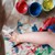 Kinderhand kleckst mit Fingermalfarben 