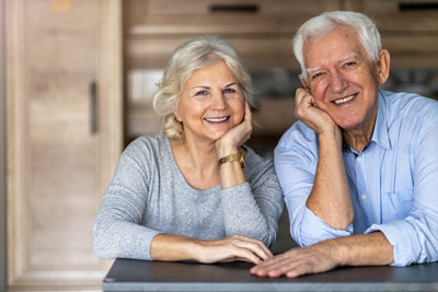 Glückliches älteres Paar lehnt zusammen am Wohntisch