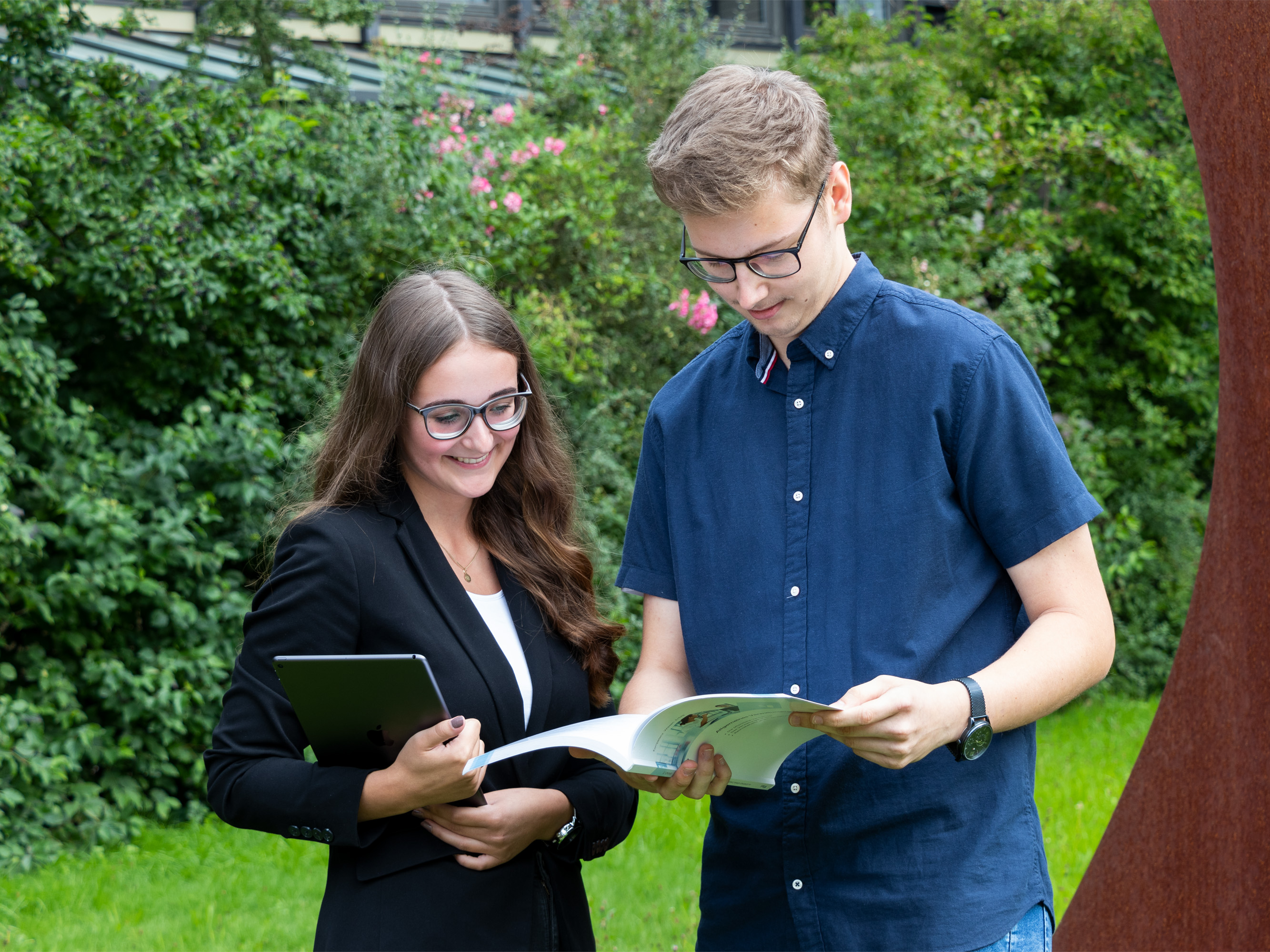 Zwei Auszubildende lesen eine Landkreisbroschüre