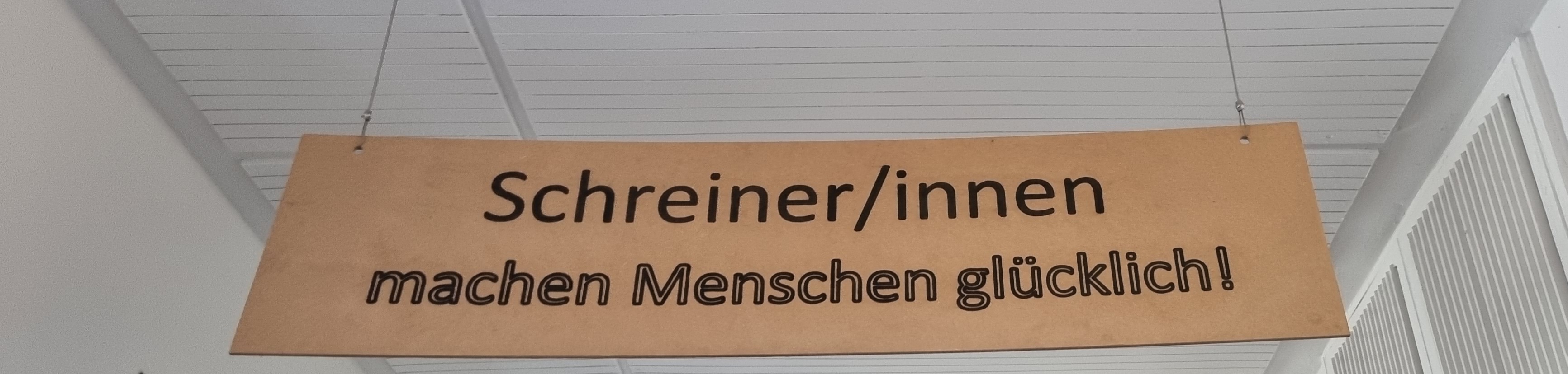 Beschriftetes Schild: Schreiner machen Menschen glücklich