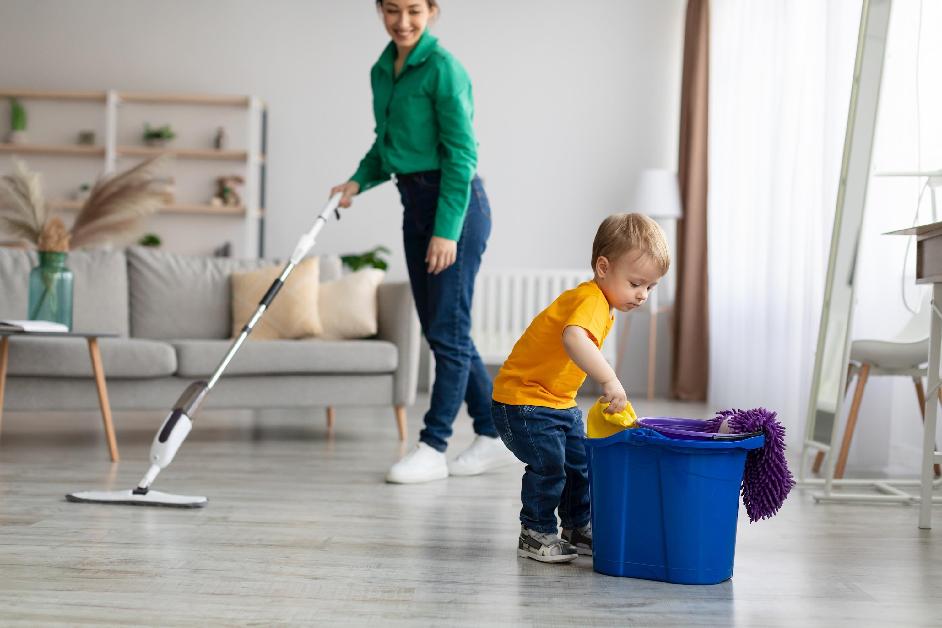 Kleiner Junge hilft Mutter beim Putzen