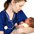 Krankenschwester hält neugeborenes Kind im Arm