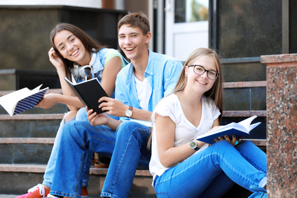Studenten lesen, während sie draußen auf einer Treppe sitzen