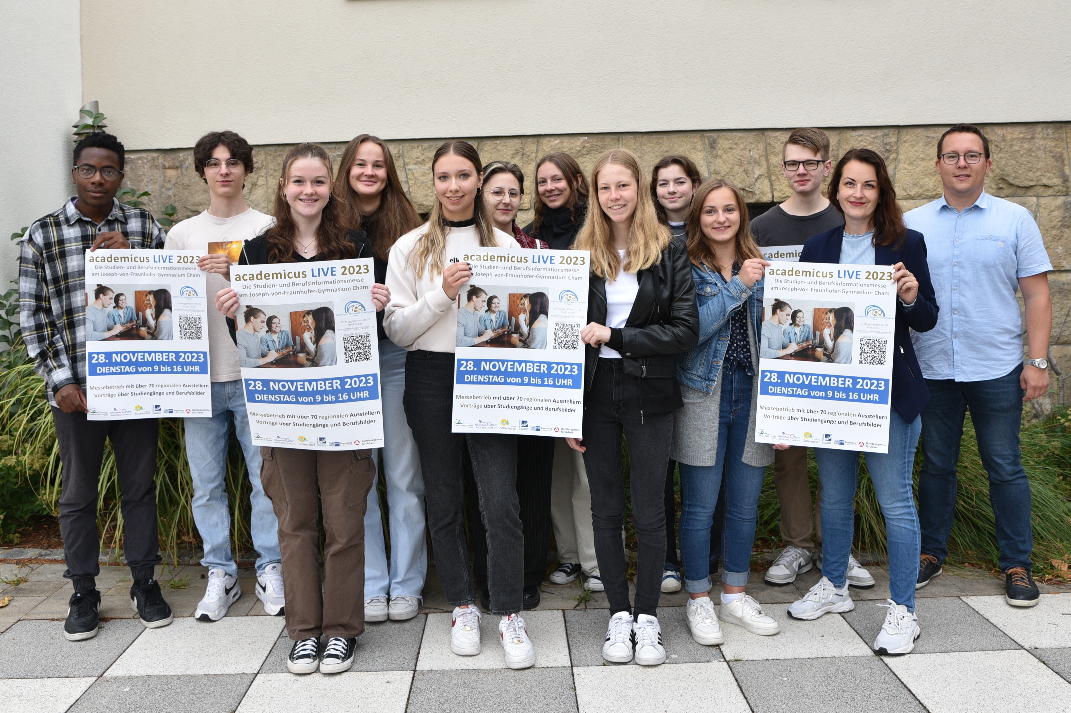 Gruppe mit Plakaten: Vorankündigung der Messe Academicus 2023