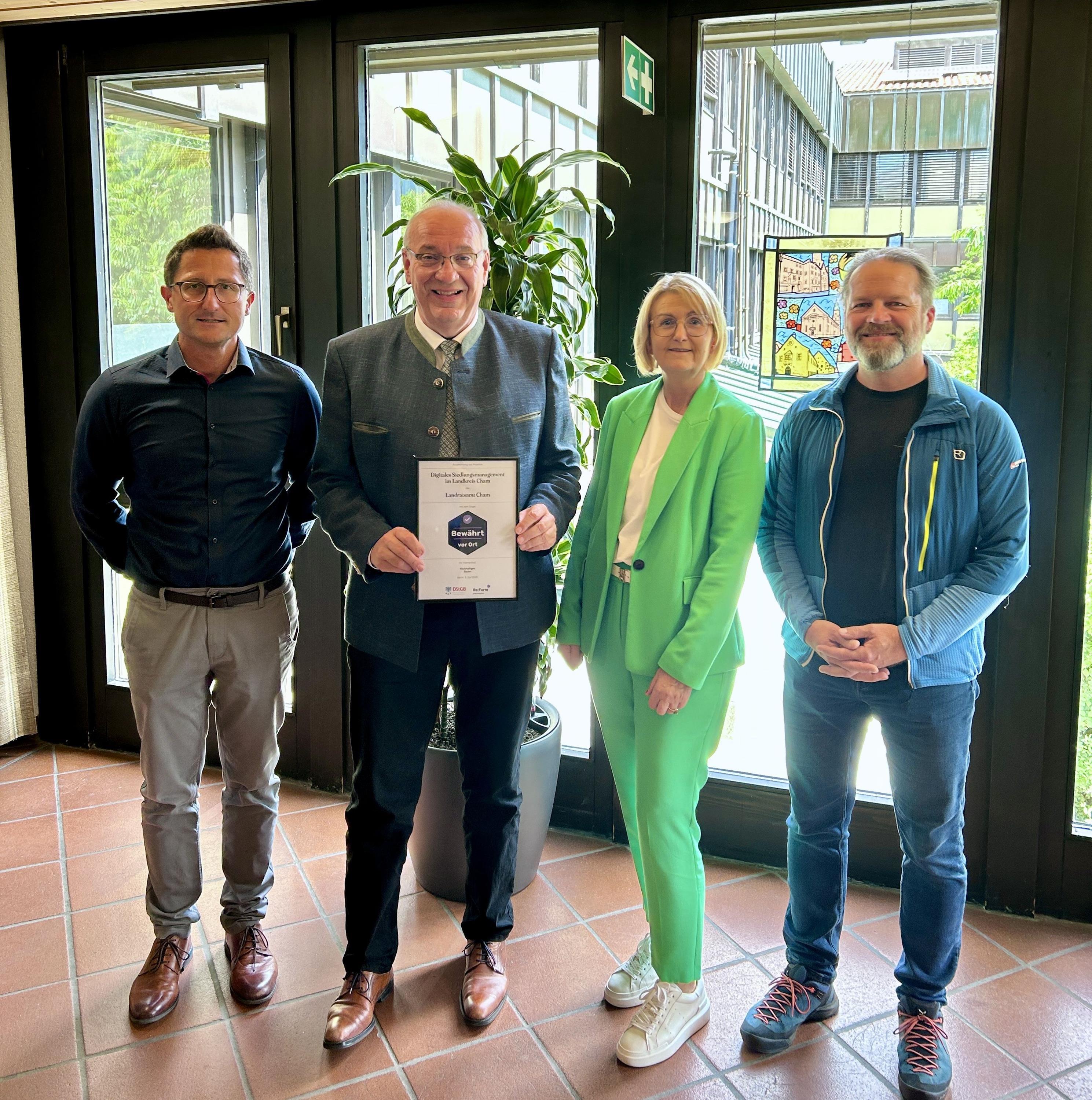 Landrat und Mitarbeitende mit Urkunde 
