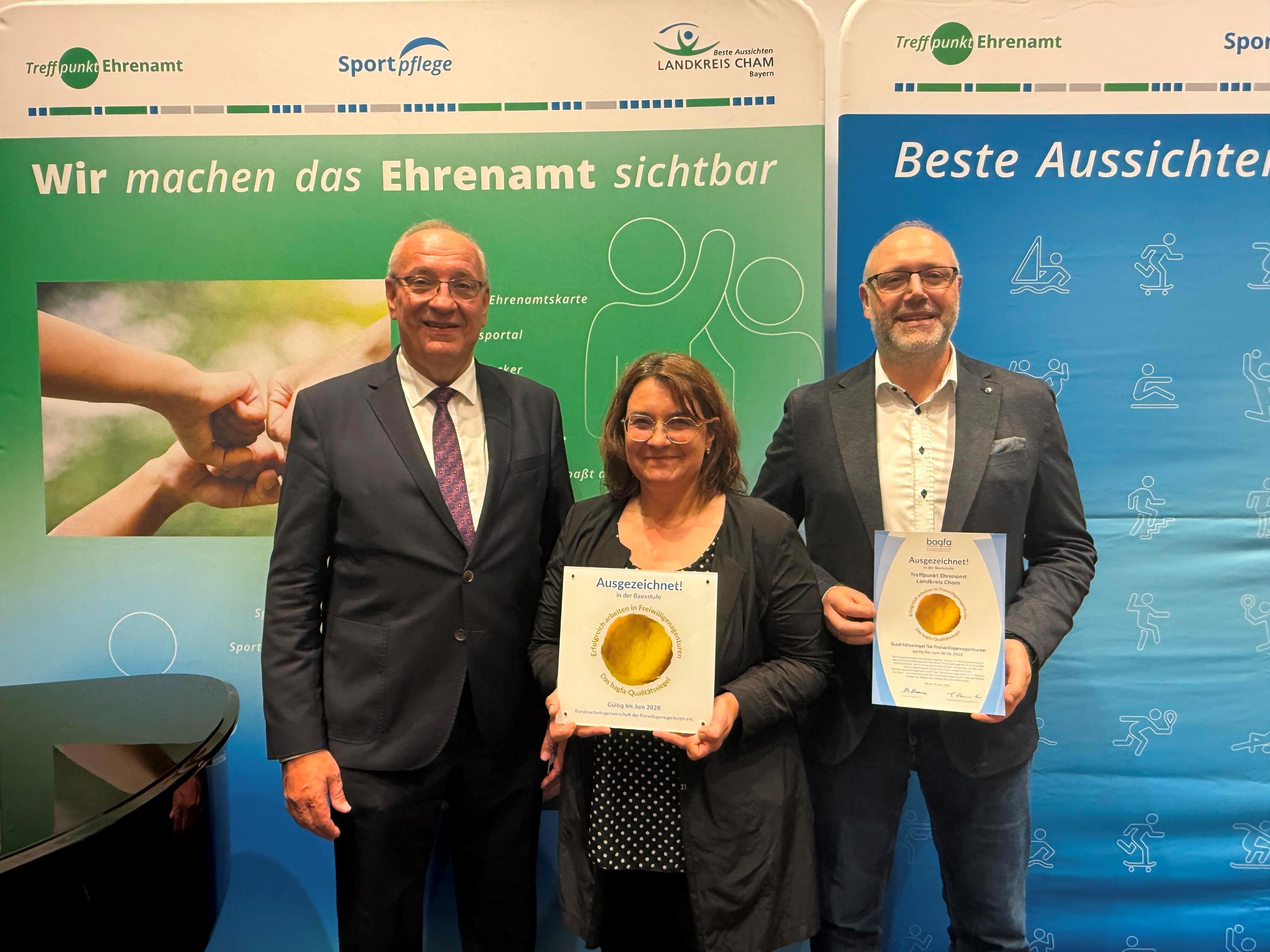 Drei Personen mit Urkunden